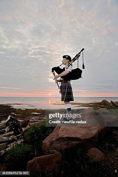 canada, prince edward island, point prim, woman playing bagpipes on shore - woman kilt stock pictures, royalty-free photos & images