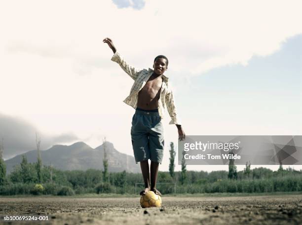 south africa, cape town, hout bay, portrait of boy (14-15) balancing on ball - barefoot teen boys stock pictures, royalty-free photos & images