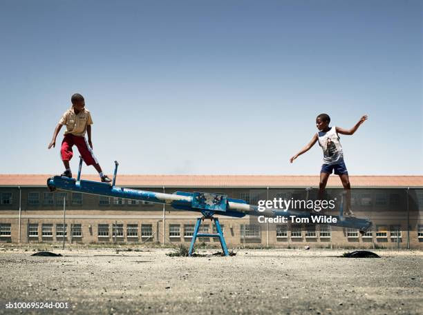 south africa, cape town, langa, boys (12-14) balancing on seesaw - gungbräda bildbanksfoton och bilder