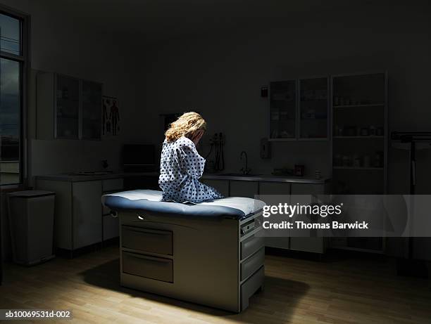 patient sitting on examination table, rear view - examining table stock pictures, royalty-free photos & images