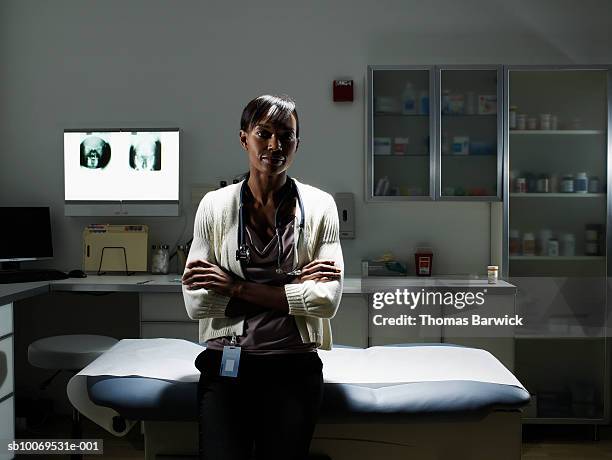 female doctor in examination room smiling, portrait - kabinet dokter stockfoto's en -beelden