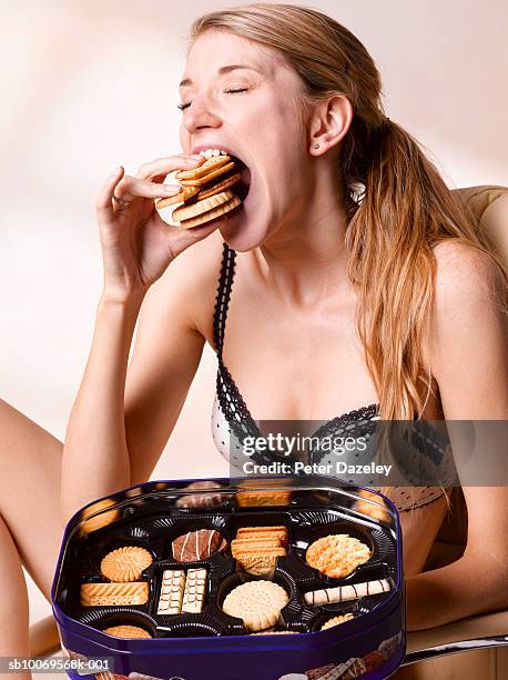 young woman eating biscuits, close-up - very thin woman stock pictures, royalty-free photos & images