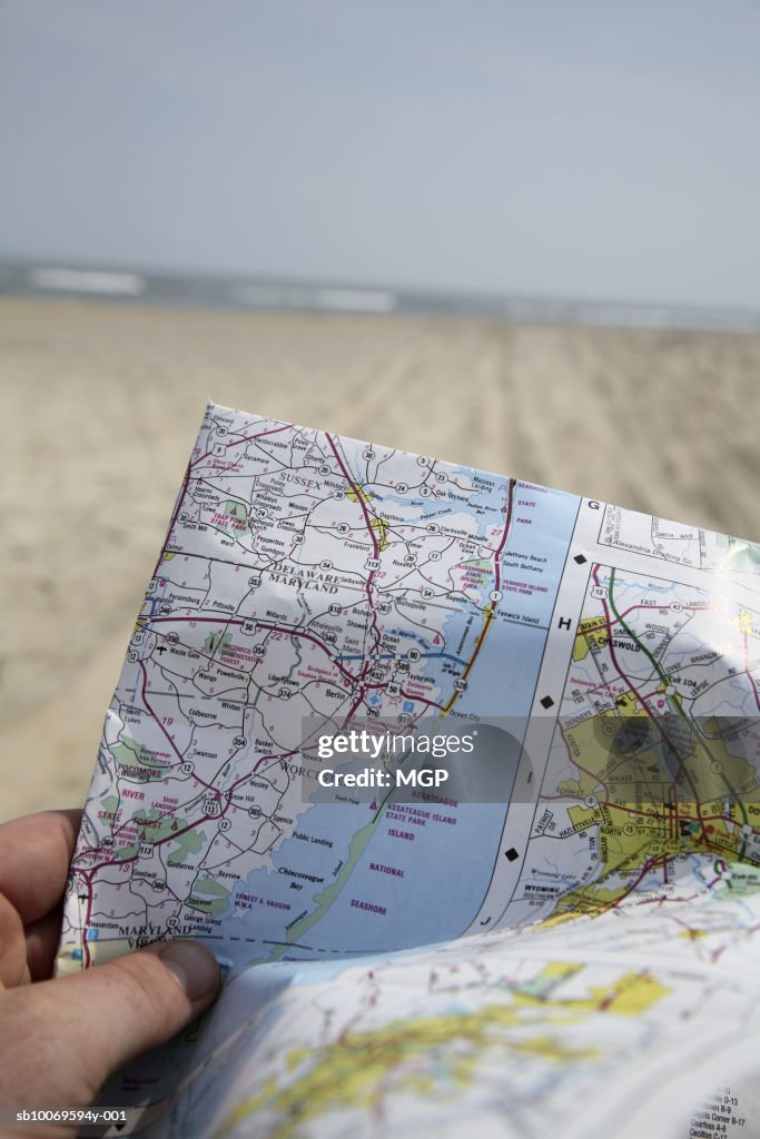 Person holding map, close-up of hands