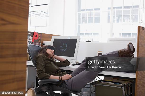 young businesswoman reclining with feet on desk in office - devagar - fotografias e filmes do acervo