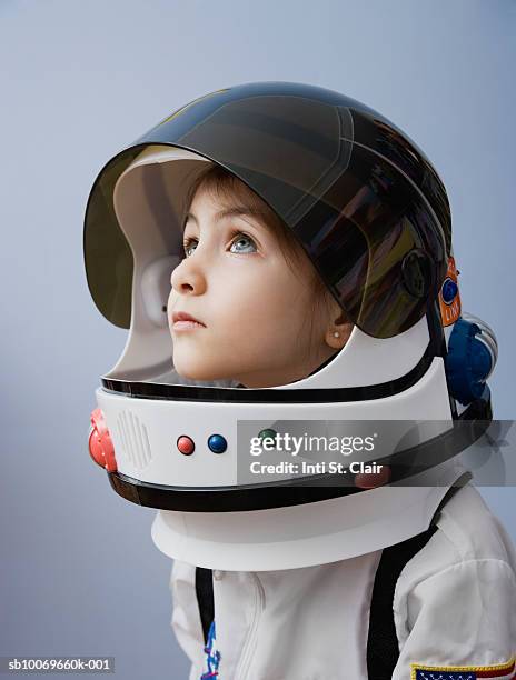 girl (4-5 years) wearing space costume, studio shot - casco da astronauta foto e immagini stock