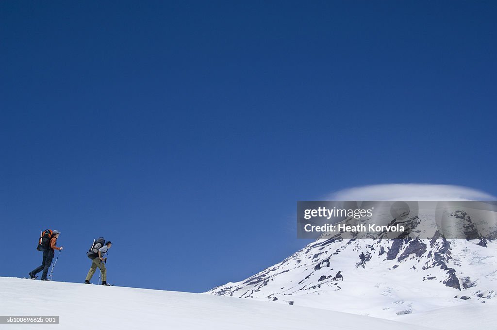 USA, Washington State, Cascade Mountains, two hikers walking on mountain ridge, side view
