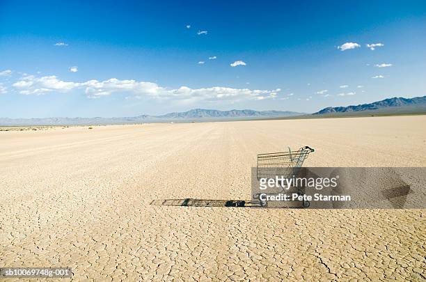 empty shopping cart in desert - disappear stockfoto's en -beelden