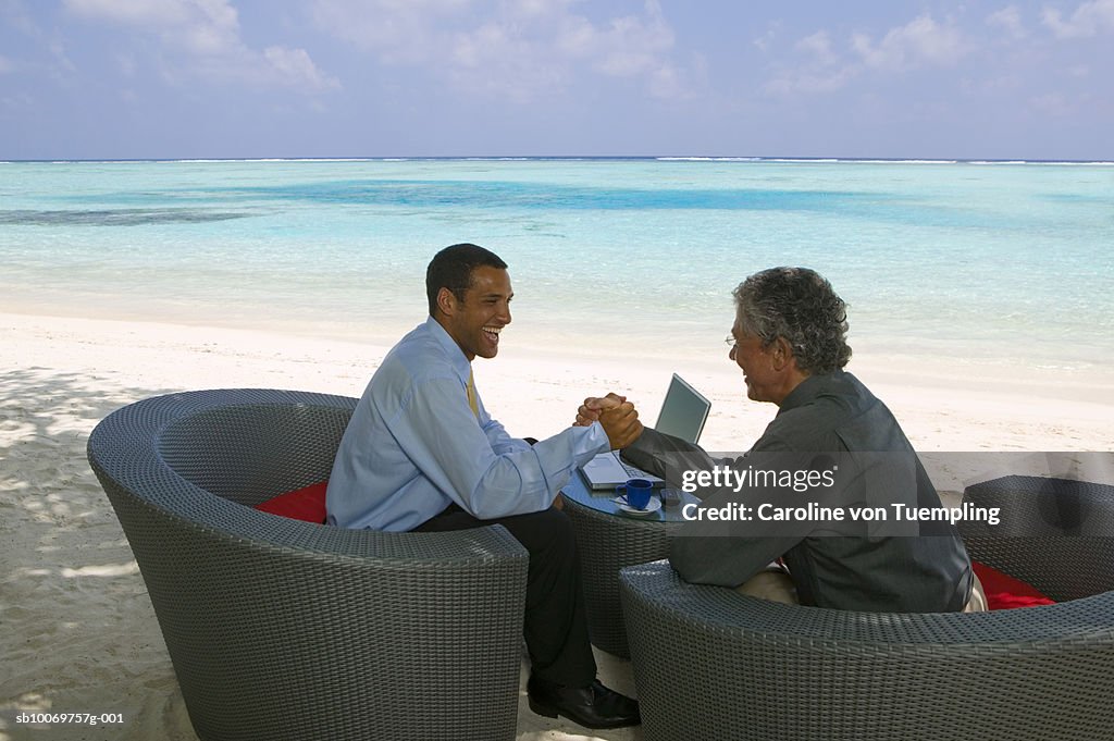 Businessmen on beach, smiling