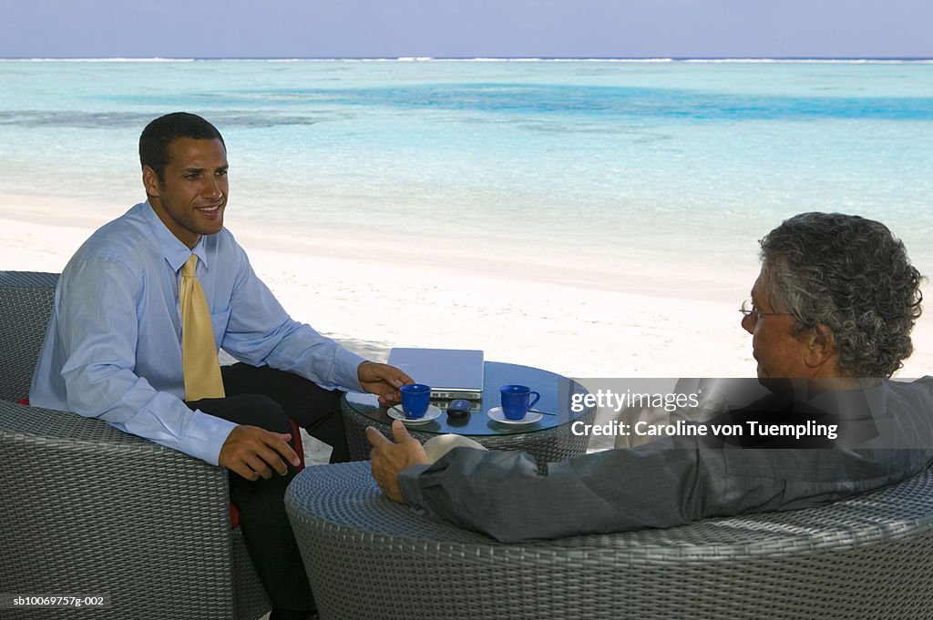 Businessmen on beach, smiling