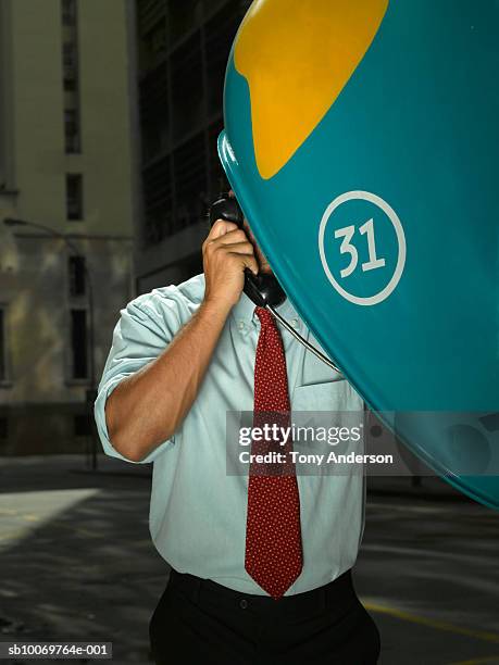 young businessman talking on pay phone on street - public phone stock pictures, royalty-free photos & images