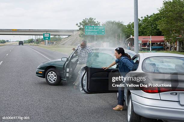 mature man and woman getting out of car after accident - accident car photos et images de collection