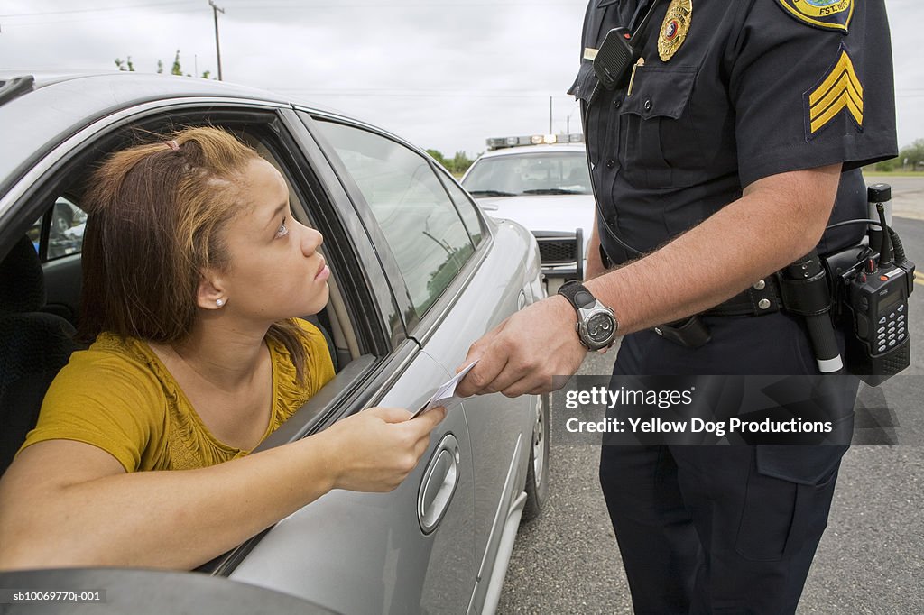 Police officer taking license of teenage girl (16-17)