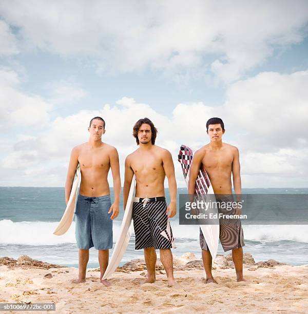 young men with surfboard on beach, portrait - muscle men at beach stock-fotos und bilder
