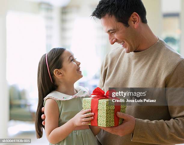girl (4-5) giving gift to father - child giving gift stock-fotos und bilder