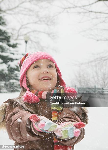 girl (4-5) catching snowflakes, smiling - catching snowflakes stock pictures, royalty-free photos & images