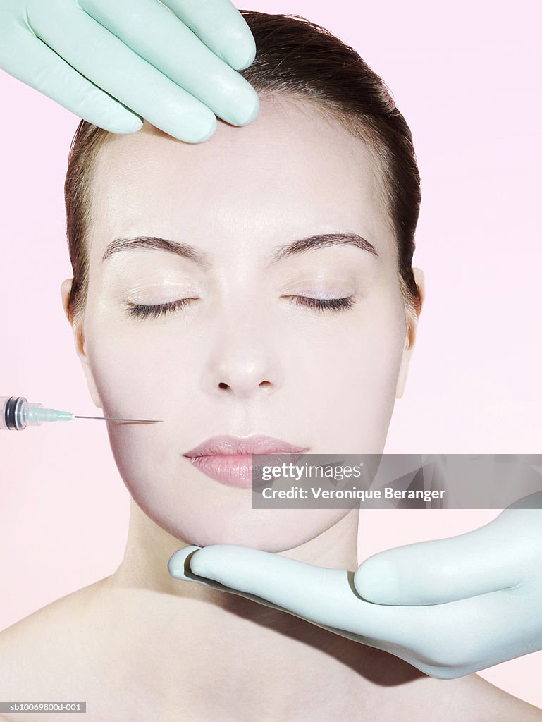 Hands in surgical gloves holding woman's head