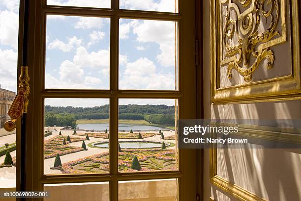 france, paris, palace of versailles, gardens seen through window - versailles stockfoto's en -beelden
