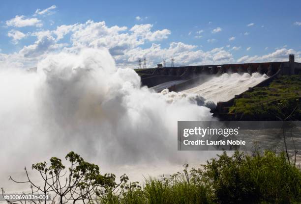 brazil, itaipu dam, water flowing over spillway of dam - paraná fotografías e imágenes de stock