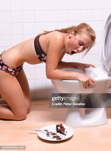 teenage girl (16-17) with chocolate cake vomiting into toilet bowl - girls in bras fotos stock-fotos und bilder