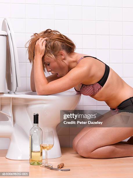 teenage girl (16-17) vomiting into toilet bowl - girls in bras photos fotografías e imágenes de stock