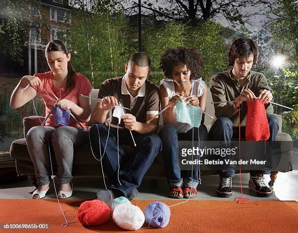 group of people knitting on sofa in living room - knitting stock pictures, royalty-free photos & images