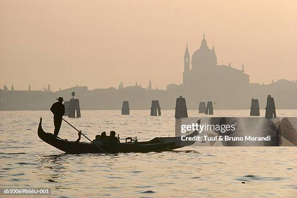italy venice, gondola on venetian lagoon at sunset - gondola traditional boat stockfoto's en -beelden