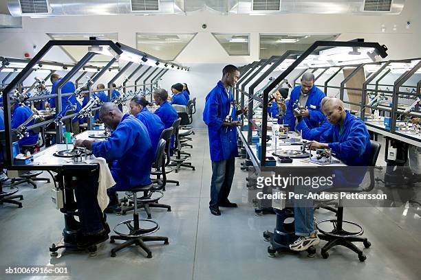 Workers polish diamonds at a newly opened factory on March 18, 2008 in Gaborone, Botswana. Steinmetz, an Israeli based company opened the factory and...