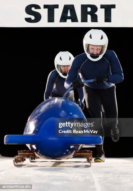 men pushing bobsleigh, portrait - bobsleigh team stock pictures, royalty-free photos & images