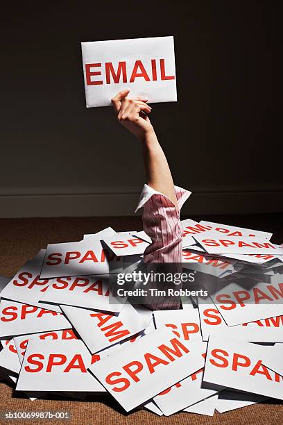 businesswoman hand reaching out of pile of spam envelopes and holding e-mail envelope - e mail spam ストックフォトと画像