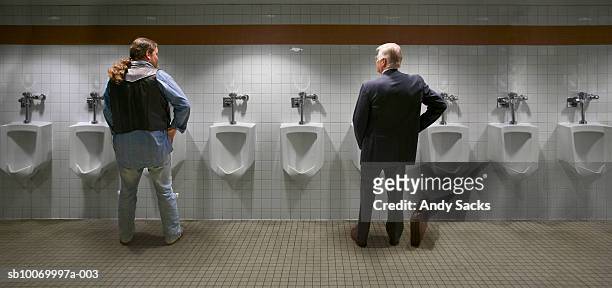 two men standing at urinal, rear view (digital composite) - bathroom arrangement stock pictures, royalty-free photos & images