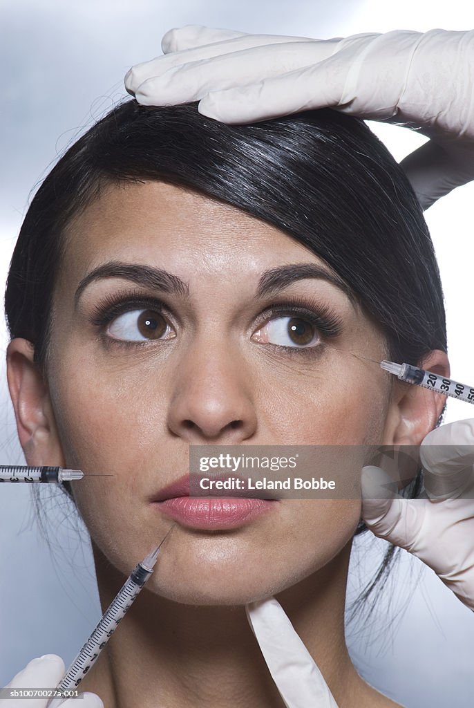 Woman receiving skin smoothing injections on face, close-up