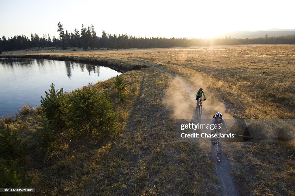 USA, Oregon, Bend, two cyclists on trail by river