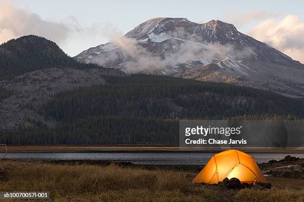 usa, oregon, bend, illuminated tent by lake in mountains - tent ストックフォトと画像