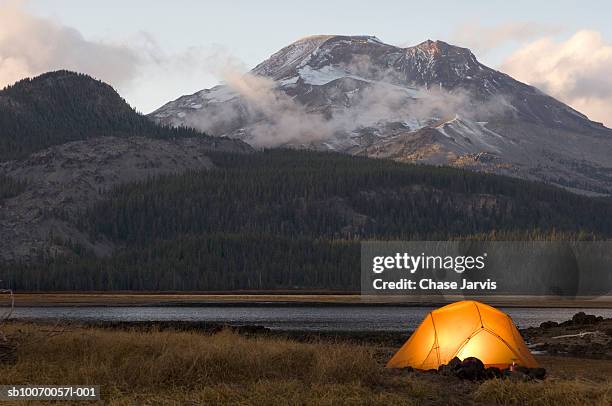 usa, oregon, bend, illuminated tent by lake in mountains - camp tent stockfoto's en -beelden