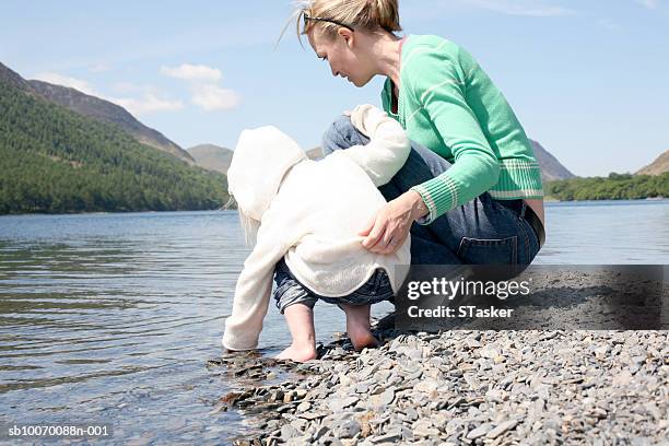 girl (2-3) with mother on lakeshore - white hoodie back stock pictures, royalty-free photos & images