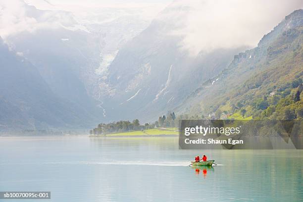 norway, western fjords, nordfjord, people in rowboat on lake in mountains - olden foto e immagini stock