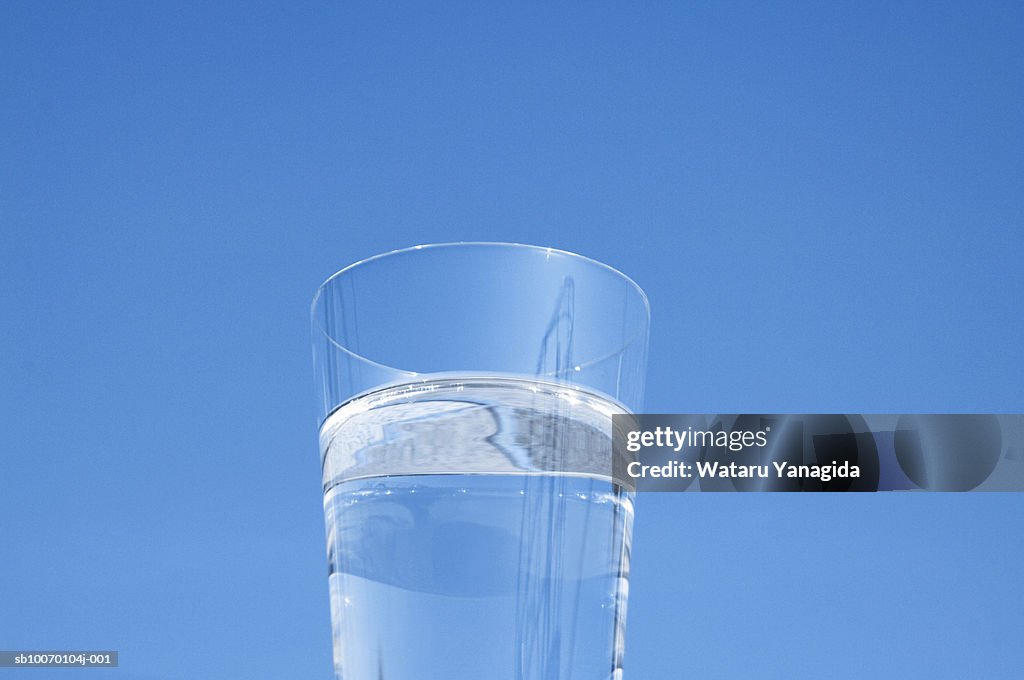Glass of water against sky