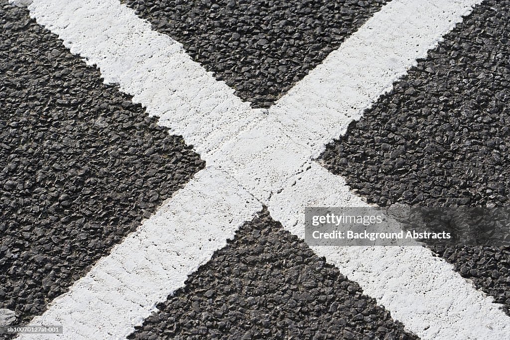 White cross shape on tarmac road