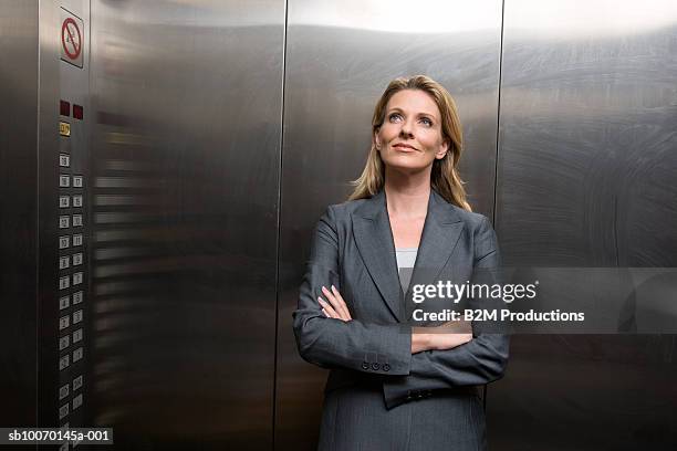 business woman standing in elevator - aufzug business stock-fotos und bilder