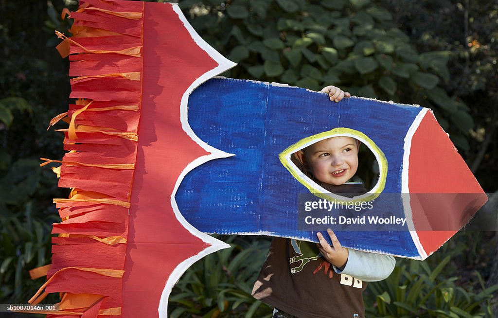 Boy (2-3) playing with cardboard rocket