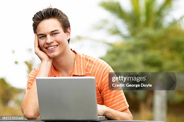 close up portrait of teenage boy (16-18) sitting in front of laptop - only teenage boys stock pictures, royalty-free photos & images