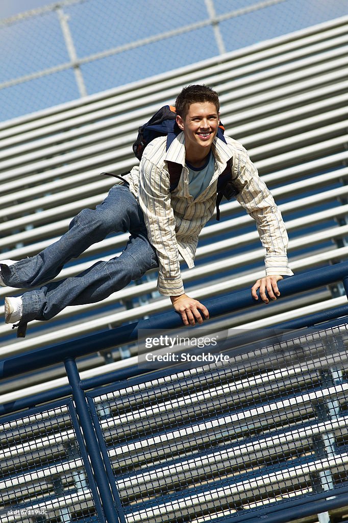 Teenage boy (16 - 18) jumping over a railing