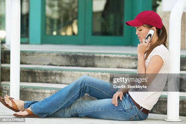 teenage girl (16 - 18) talking on a mobile phone side view - one teenage girl only imagens e fotografias de stock