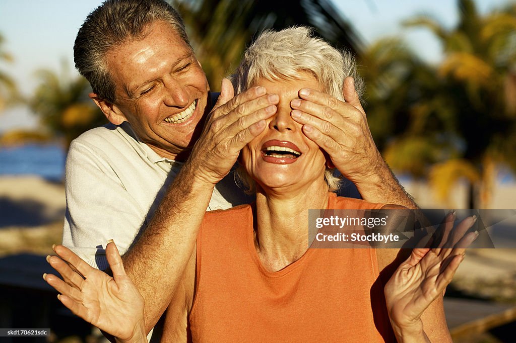 Close up of husband covering wife's eyes