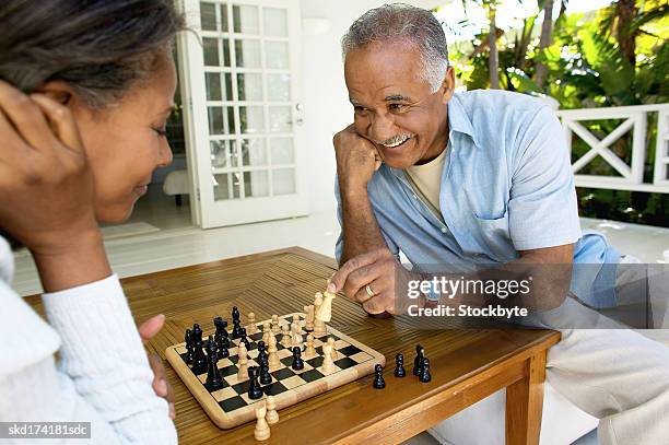 husband and wife playing chess - senior playing chess stock pictures, royalty-free photos & images