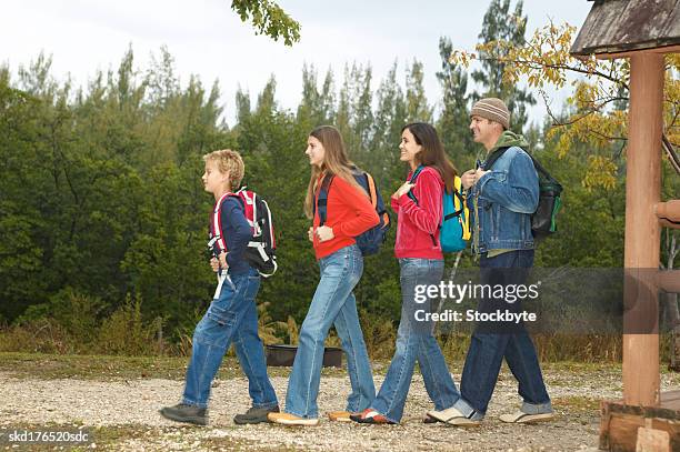 side view of a mother father daughter (15-16) and son (10-11)setting off on a walk - 10 off stock-fotos und bilder