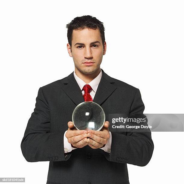 portrait of a businessman holding a crystal ball - crystal stock-fotos und bilder