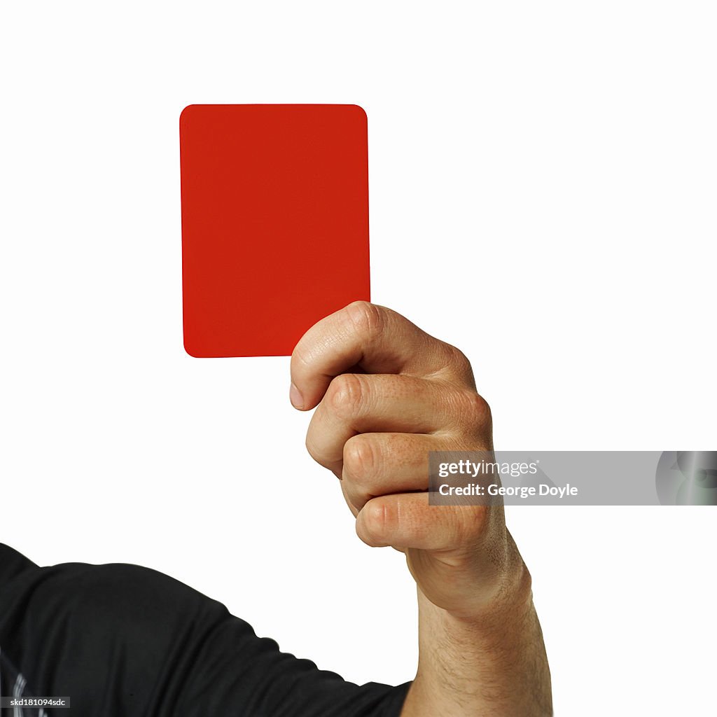 Close up of a referee holding up a red card