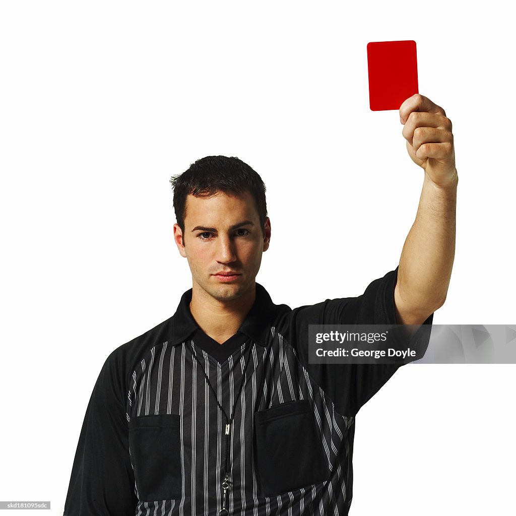 Portrait of a football referee holding up a red card
