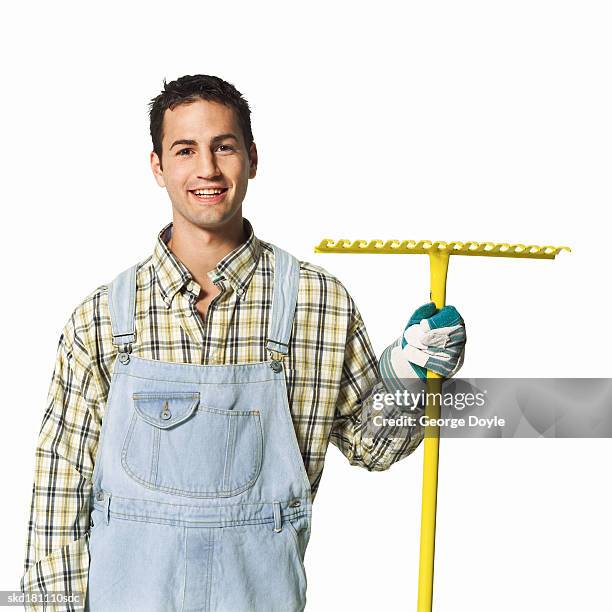 portrait of a gardener holding a rake - rake stock-fotos und bilder